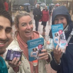 Le promoteur de Zooroyal remet un flyer à des passants souriants