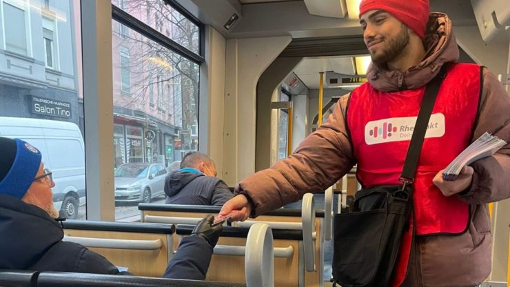 Ambassadeur de la marque distribue des cartes d'information dans les transports en commun de la Rheinbahn