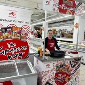 Promotrice derrière un stand de dégustation de spécialités asiatiques
