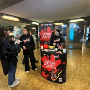 Une étudiante est informée sur les sauces Buldak par deux ambassadeurs de marque